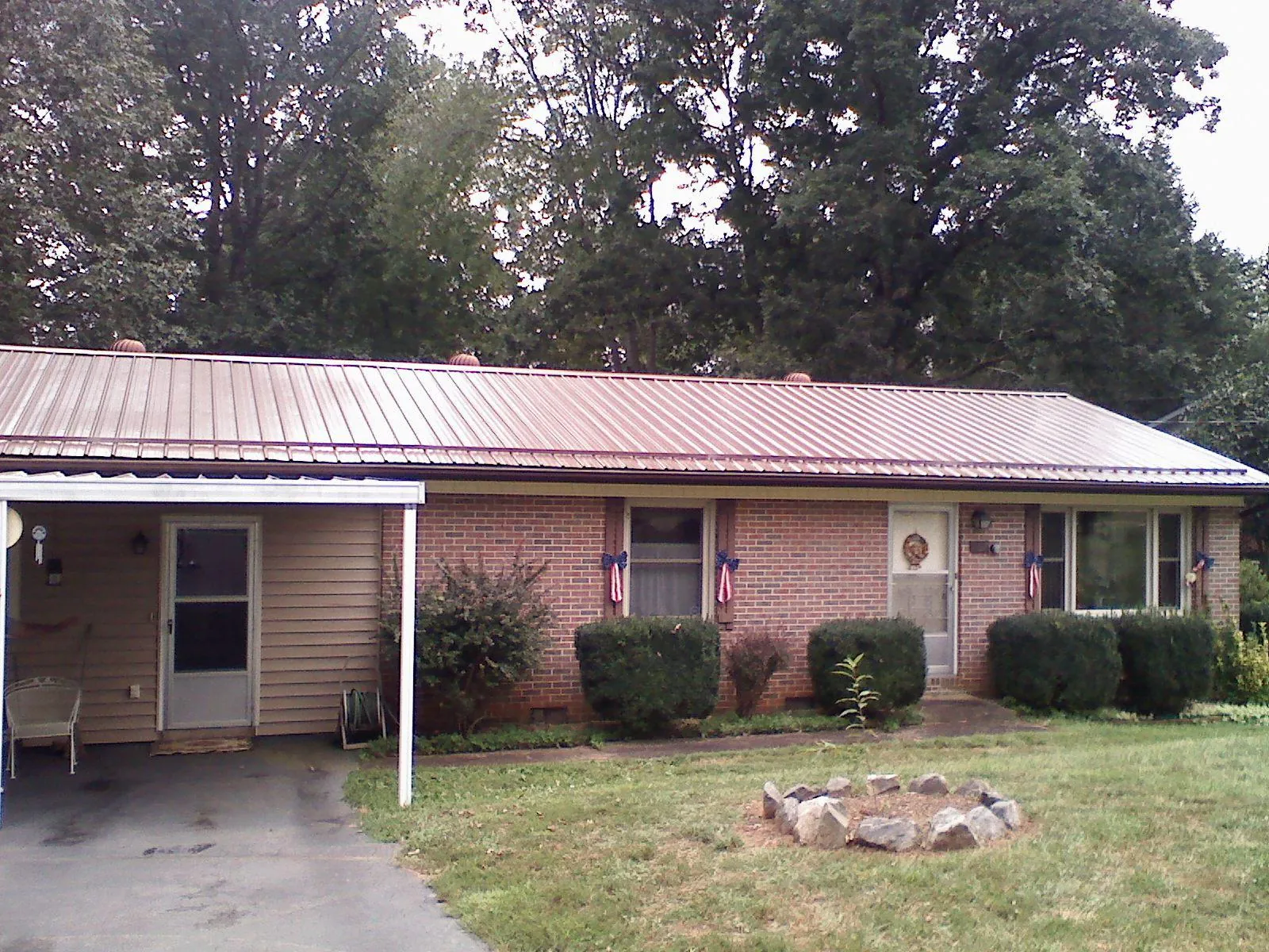 Bronze metal roof and carport on a brick ranch home — Roof Repair work by our crew in Orovada